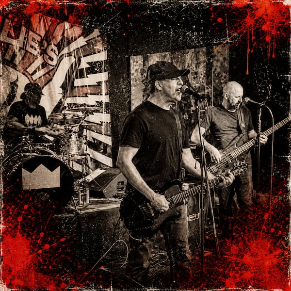 Demons and Disciples performing live on stage with a gritty black-and-white punk rock style and red grunge accents.